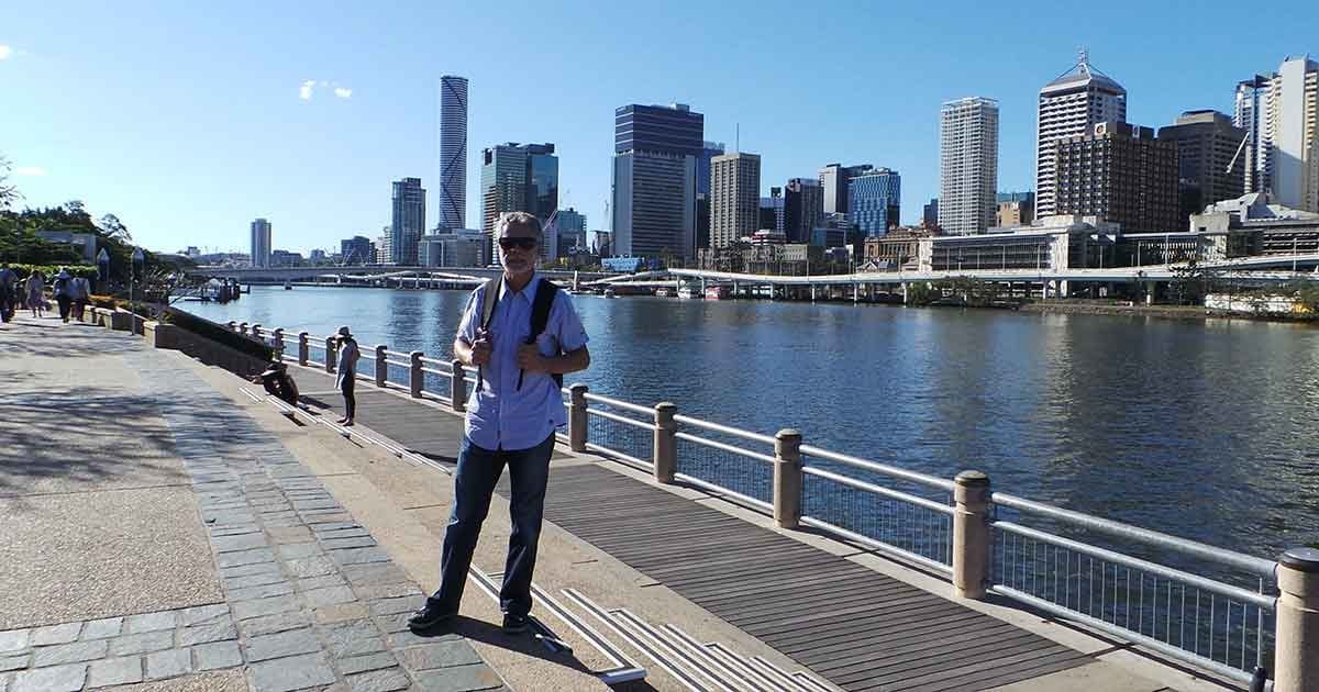 Experiencia Tomás hombre posando delante de una ciudad con rascacielos y un lago